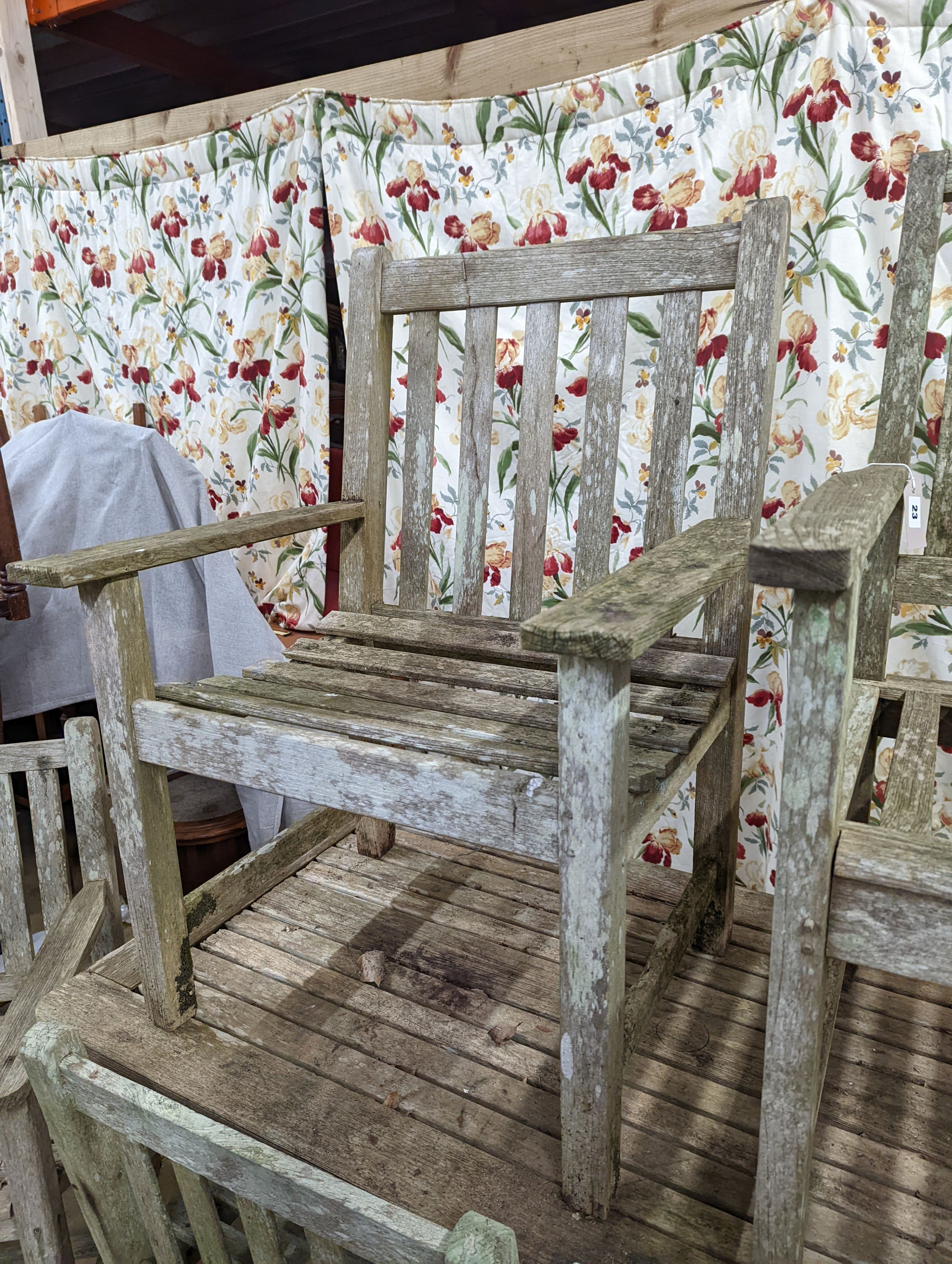 A weathered teak rectangular garden table and six elbow garden chairs, not matching. Table measures, W-149cm, D-70cm, H-75cm.